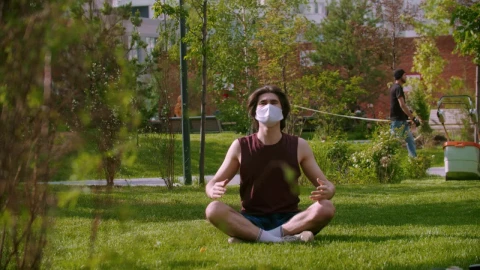 Stock Video A Young Man Wearing A Medical Mask Meditating On The Live Wallpaper For PC - For Wallpaper