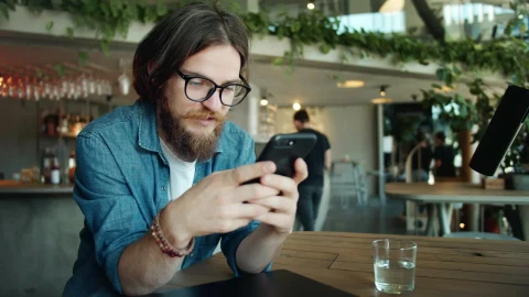Stock Video Bearded Man Using Mobile App In Airport Cafe Live Wallpaper For PC - Live Wallpaper