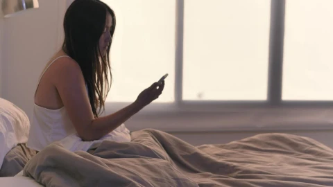 Stock Video Girl Checking Her Cell Phone In Her Bed Upon Waking Live Wallpaper For PC - Live Wallpaper
