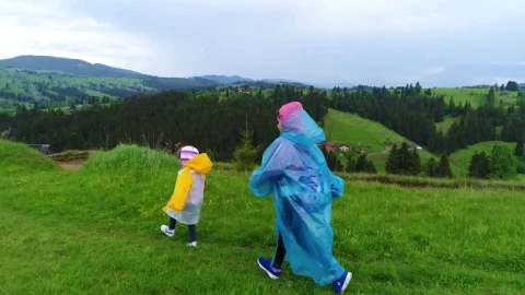 Stock Video Happy Sisters Walking Through The Field Wearing Raincoats Animated Wallpaper - Wallpaper Wallpaper