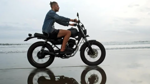 Stock Video Man In Denim Jacket Riding Motorcycle On Beach Animated Wallpaper - Fond d'écran animé gratuit