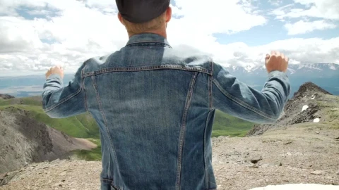 Stock Video Man In Denim Jacket Raises Arms To Mountain Landscape Animated Wallpaper - Fond d'écran animé gratuit