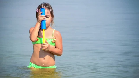 Stock Video Little Girl Playing With A Water Toy In The Sea Animated Wallpaper - In Wallpaper