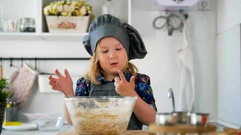 Stock Video Little Girl In A Kitchen Stirring A Cookie Mix Animated Wallpaper - In Wallpaper