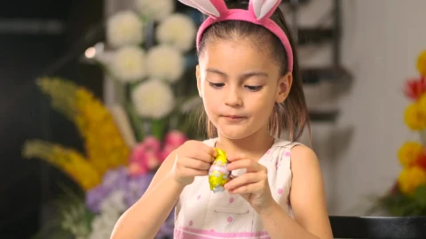 Stock Video Little Girl Eating An Easter Egg With Chocolate Animated Wallpaper animated wallpaper preview
