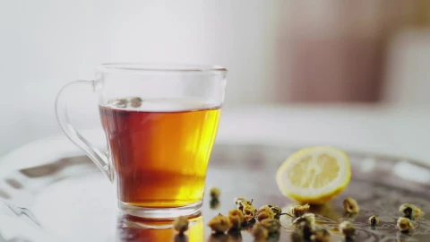 Stock Video Lemon Slice Dropped Into Tea In Clear Glass Animated Wallpaper - In Wallpaper