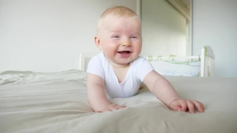 Stock Video Laughing Baby On Bed In White Room Animated Wallpaper - In Wallpaper