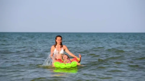 Stock Video Mother Playing With Her Daughters On A Floaty In Th Animated Wallpaper - In Wallpaper