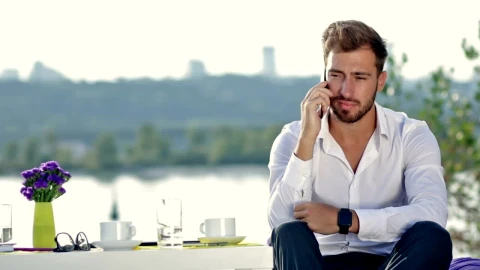 Free Stock Video Young Man At A Table Outdoors On A Call Live Wallpaper - Stock Wallpaper