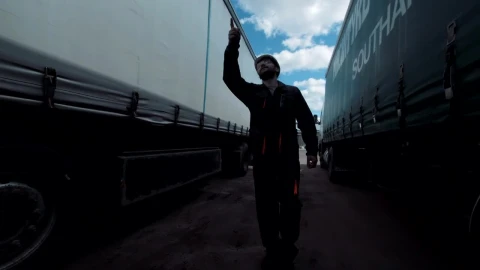 Stock Footage Worker Walking Between Two Freight Trucks Live Wallpaper Free - Wallpaper Wallpaper