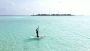 Stock Video A Couple Paddling On Boards On Turquoise Sea Live Wallpaper for PC