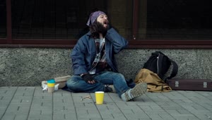 Stock Video A Drunk Homeless Man Sitting On The Street Live Wallpaper for PC