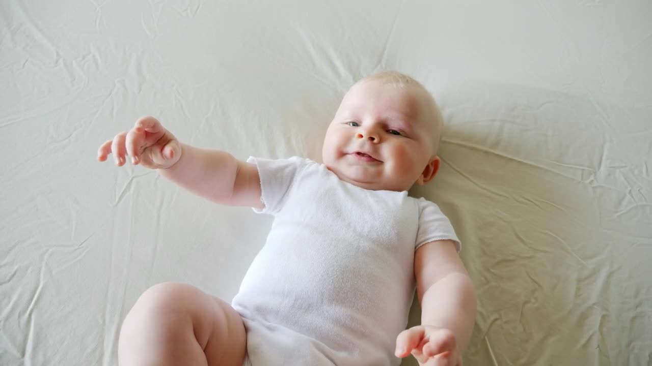 Download Stock Video Baby On White Bed Smiling And Reaching Live Wallpaper For PC