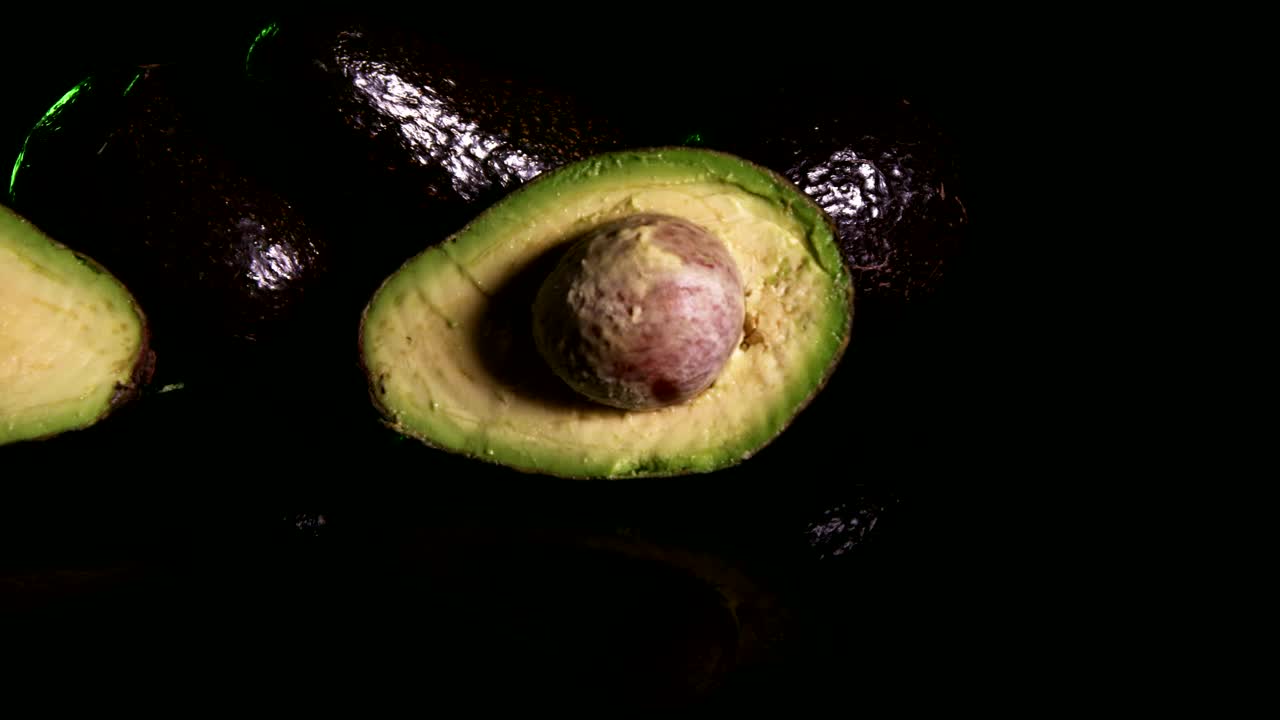 Download Stock Video Avocado Sliced In Half On A Dark Background Live Wallpaper For PC