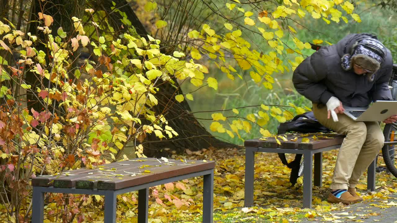 Download Stock Video A Young Man With A Laptop On A Park Bench Live Wallpaper For PC