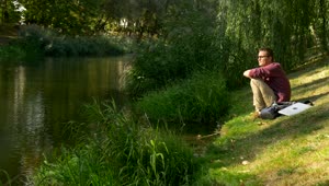 Stock Video A Man Sitting On The Riverside Thinking Live Wallpaper For PC