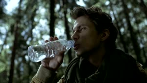 Stock Video A Man Drinks Water From A Bottle In The Woods Live Wallpaper For PC