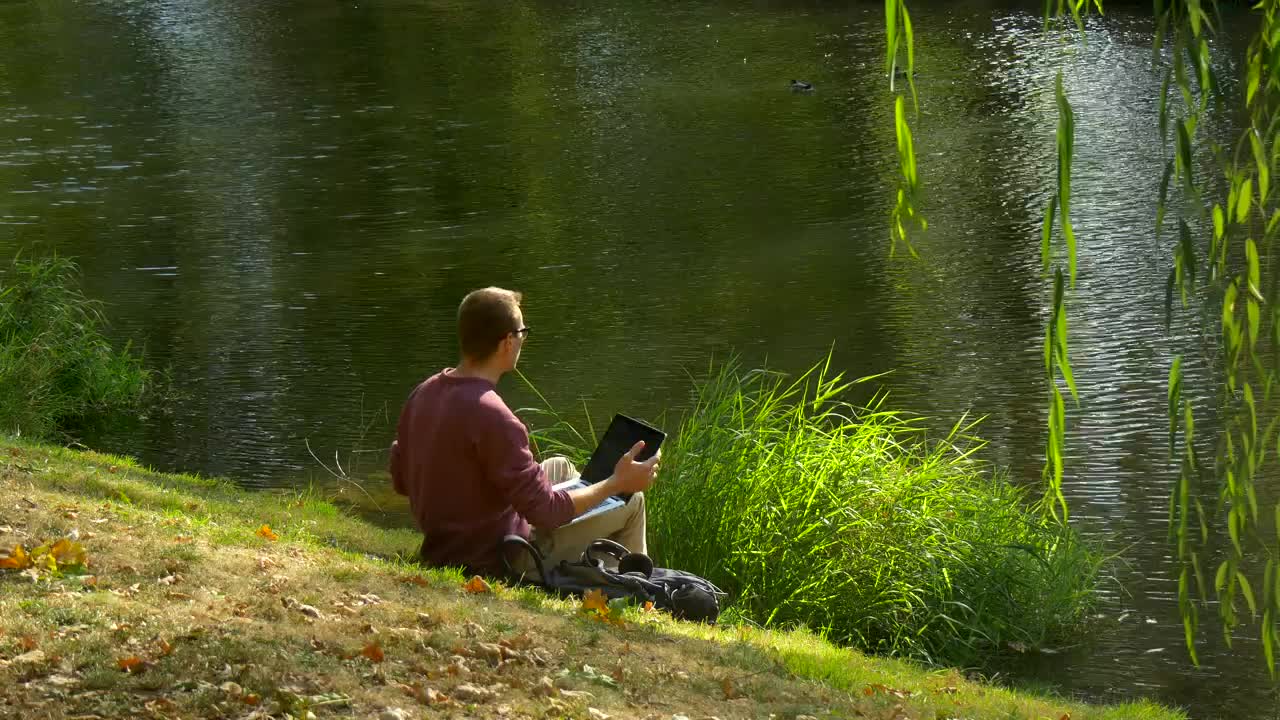 Download Stock Video Boy Working Relaxed On The Bank Of A River Live Wallpaper For PC
