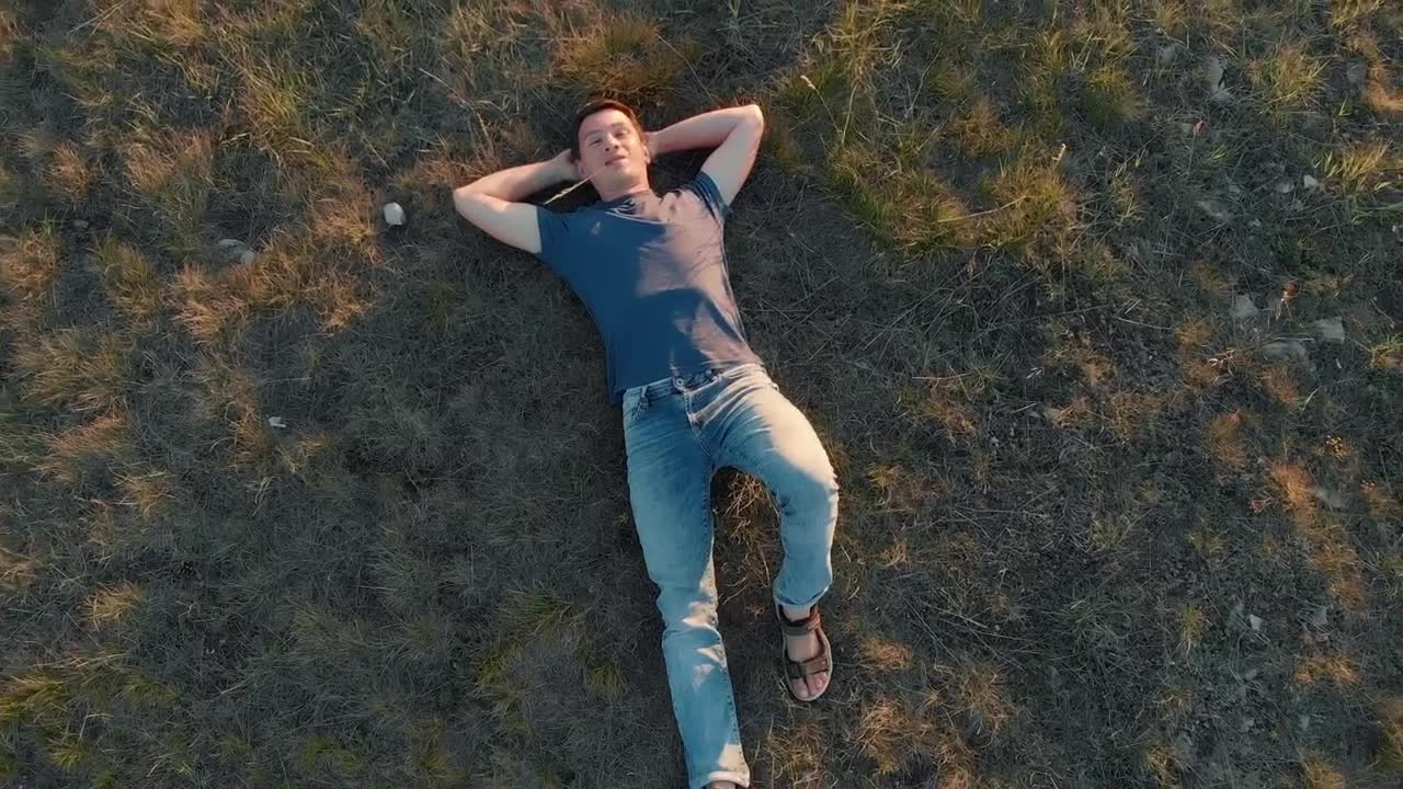 Download Stock Video Boy Lying Outdoors Top Zoom Out Aerial Shot Live Wallpaper For PC