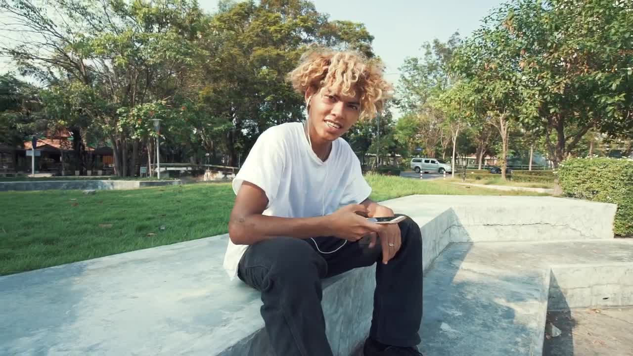 Download Stock Video Boy Listening To Music With Headphones In A Park Live Wallpaper For PC