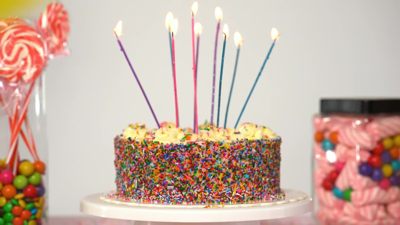 Download Stock Video Birthday Cake On A Table With Candies On A White Live Wallpaper For PC