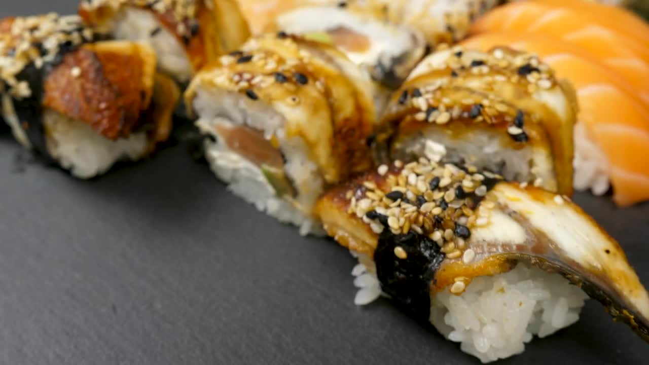 Download Video Stock Closeup Of Sushi Rolls On Black Background Live Wallpaper For PC