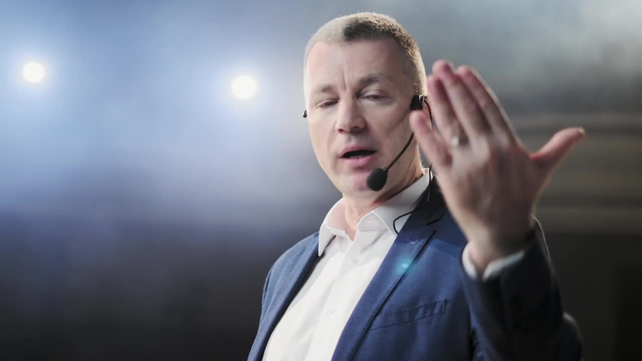 Download Video Stock Closeup Of Conference Speaker On Stage Gesturing At Camera Live Wallpaper For PC