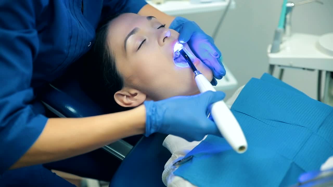 Download Stock Video Dentist Applying Blue Light To His Patient Live Wallpaper For PC