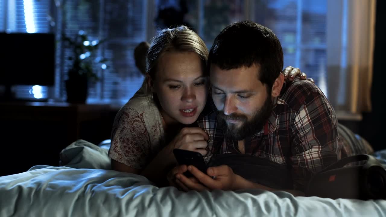 Download Stock Video Couple Watching The Smartphone In The Bed Live Wallpaper For PC