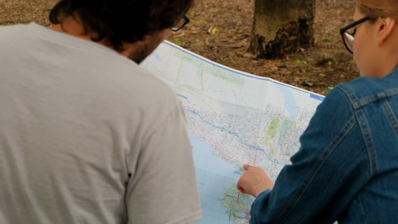 Download Stock Video Couple Of People Reviewing A Large Map Sitting In A Live Wallpaper For PC