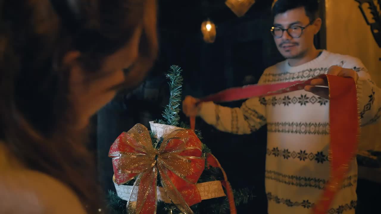 Download Stock Video Couple Of Man And Woman Decorating A Christmas Tree Live Wallpaper For PC