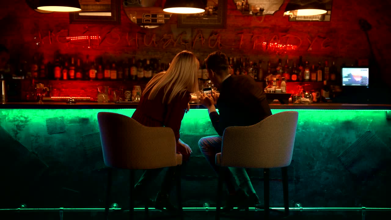 Download Stock Video Couple Checking Something In A Smartphone In A Bar Live Wallpaper For PC
