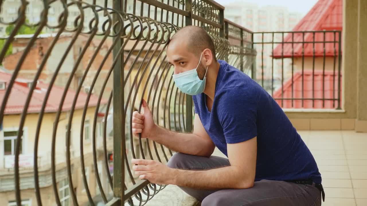 Download Stock Video Coronavirus Worries Man In Face Mask Sitting On Balcony Live Wallpaper For PC