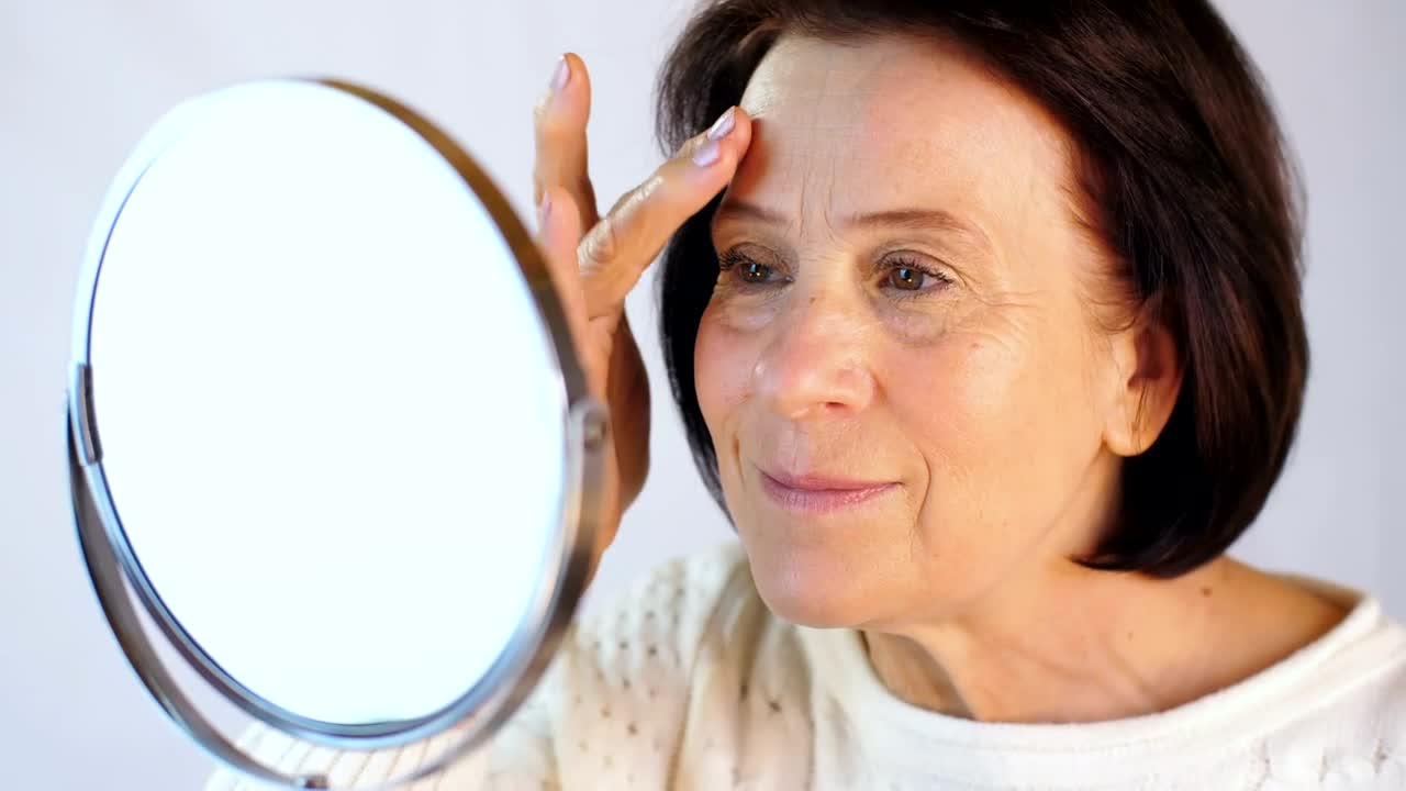 Download Stock Video Elderly Woman Touching Her Face In A Small Mirror Live Wallpaper For PC
