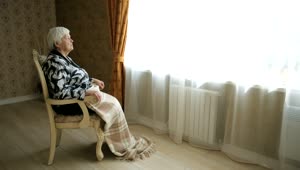 Stock Video Elderly Woman Sitting In Front Of The Window Live Wallpaper For PC