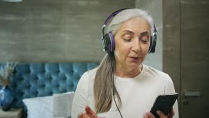 Stock Video Elderly Woman Enjoys Music App With Headphones Live Wallpaper For PC