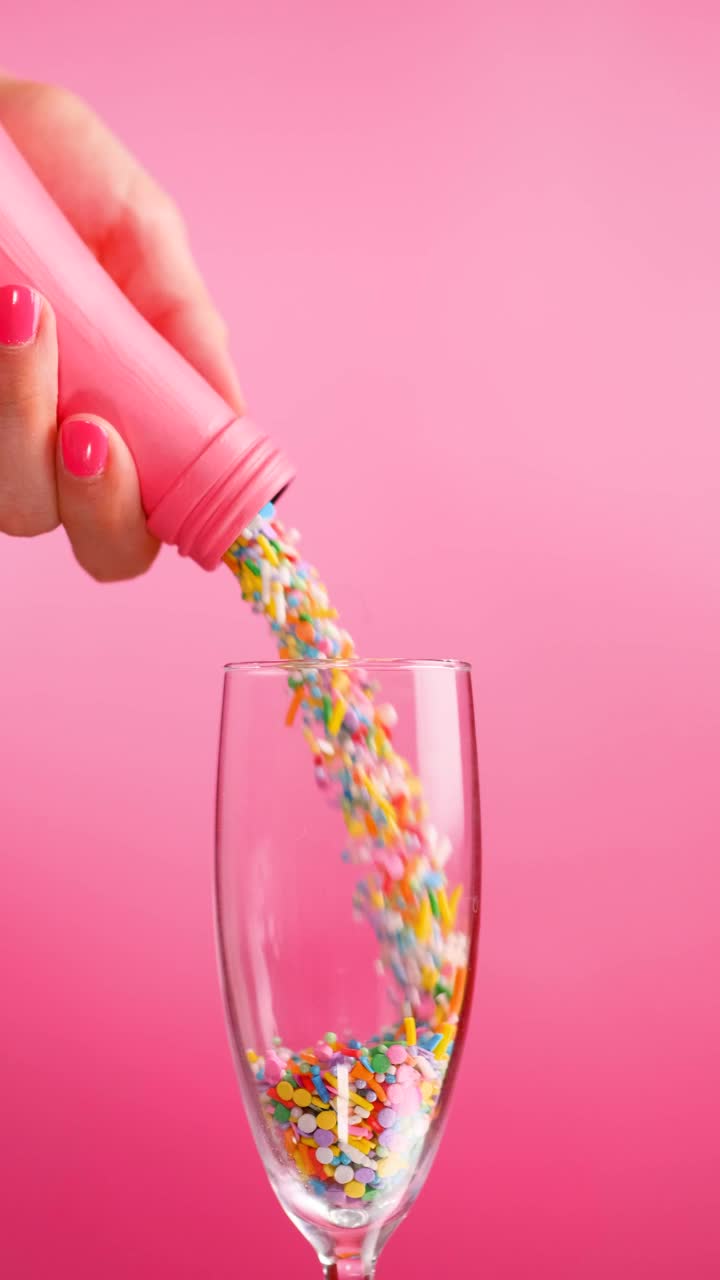 Download Stock Video Filling A Glass Cup With Small Sweets On A Pink Live Wallpaper For PC