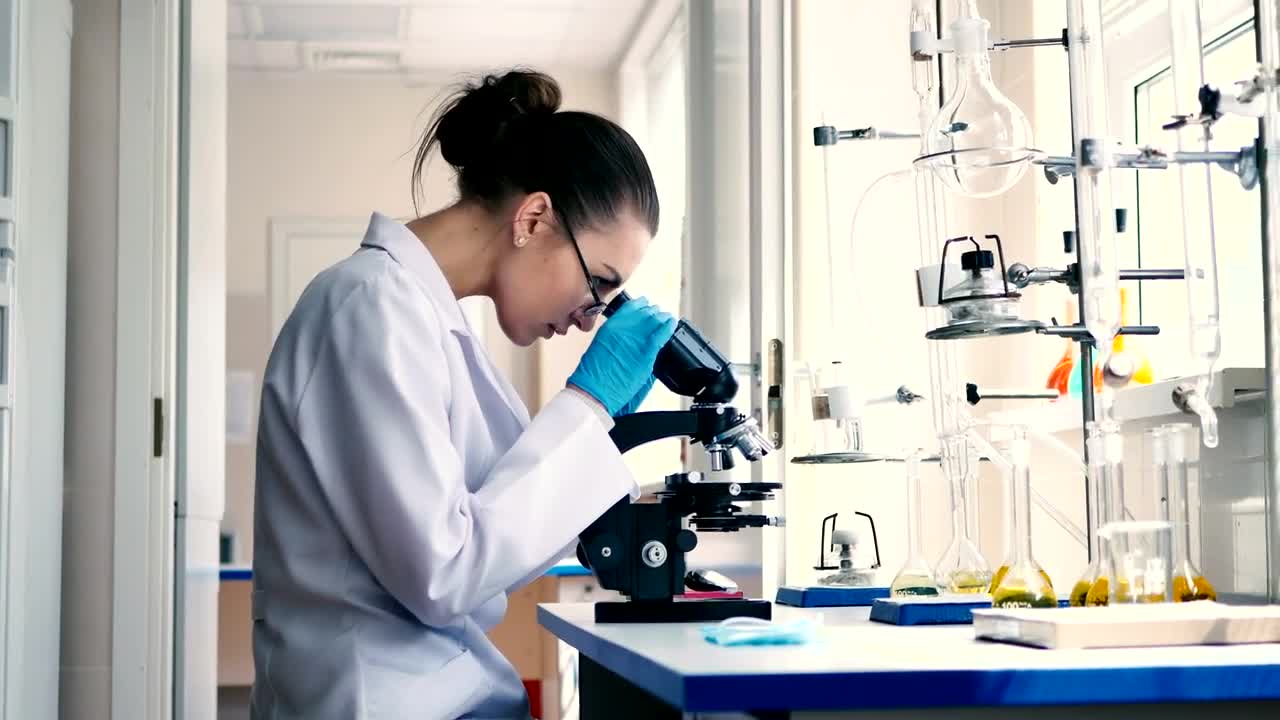 Download Stock Video Female Scientist Observing Through A Microscope Live Wallpaper For PC