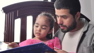 Stock Video Father Reading A Story To His Daughter In His Arms Live Wallpaper For PC