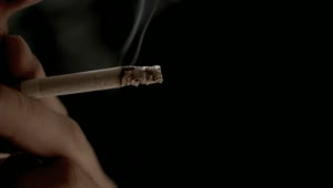Stock Video Hand Holding Cigarette With Exhaled Smoke On Black Background Live Wallpaper For PC