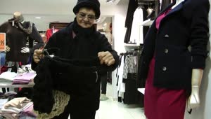 Stock Video Grandmother Choosing Winter Clothes In The Mall Live Wallpaper For PC
