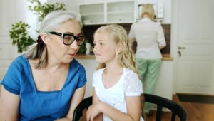 Stock Video Girl Whispers To Grandma While Mom Cooks Live Wallpaper For PC