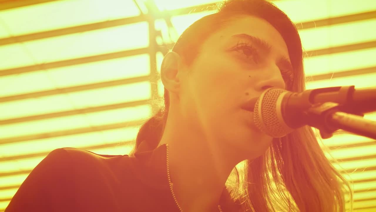 Download Stock Video Girl Singing Into A Microphone And Playing The Guitar Live Wallpaper For PC