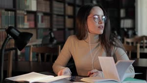 Stock Video Girl Rubs Head In Pain While Studying Late In Library Live Wallpaper For PC