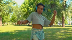 Stock Video Girl Dancing With Her Headphones In A Park Live Wallpaper For PC