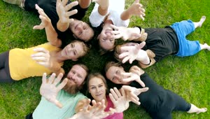 Stock Video Friends Lying On The Grass Waving At The Camera Live Wallpaper For PC