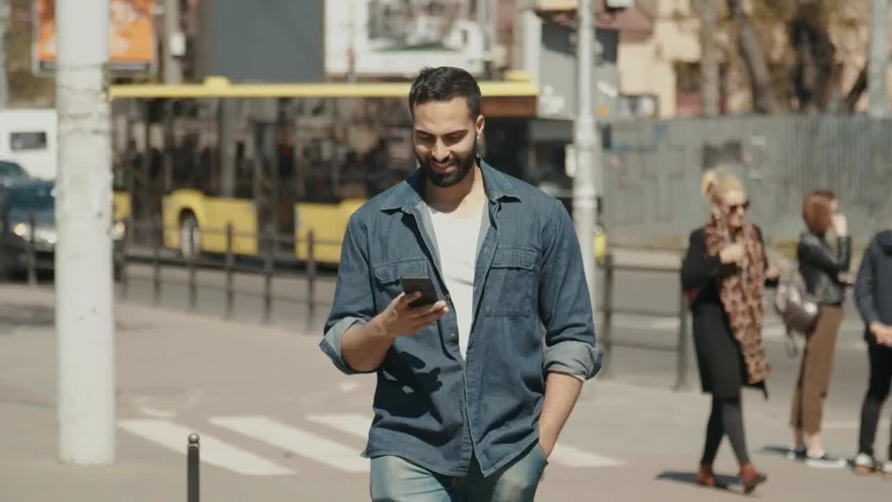 Download Stock Video Hopeful Man Smiles At Social Media While Walking Through City Animated Wallpaper