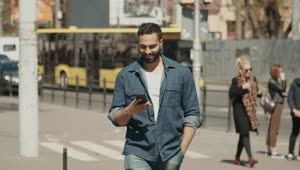 Stock Video Hopeful Man Smiles At Social Media While Walking Through City Animated Wallpaper