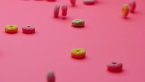 Stock Video Hoop Cereal Gliding On A Pink Surface Animated Wallpaper