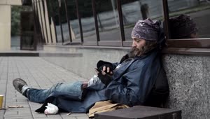 Stock Video Homeless Man Checking The Mobile Phone On The Sidewalk Animated Wallpaper